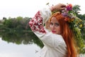 Beautiful slavic girl with long red hair and blue eyes with flower crown in embroidered ethnic suit. Feast of Ivan Kupala Royalty Free Stock Photo