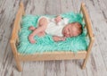 Beautiful sleeping baby on wooden cot with turquoise blanket Royalty Free Stock Photo