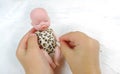 Beautiful sleeping newborn baby doll in the palms of a child, white raised background Royalty Free Stock Photo