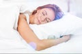 Beautiful sleeping woman in white bed with flares