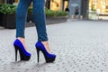 Beautiful slender female legs in tight jeans and blue shoes on a Royalty Free Stock Photo