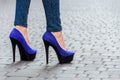 Beautiful slender female legs in tight jeans and blue shoes on a Royalty Free Stock Photo