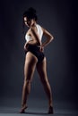 Beautiful slender girl athlete dancing barefoot under studio searchlight Royalty Free Stock Photo