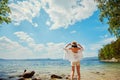 Beautiful slender girl relaxing on the rocky beach of a large la Royalty Free Stock Photo