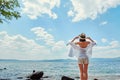 Beautiful slender girl relaxing on the rocky beach of a large la Royalty Free Stock Photo