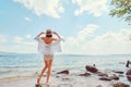 Beautiful slender girl relaxing on the rocky beach of a large lake Royalty Free Stock Photo