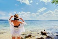 Beautiful slender girl relaxing on the rocky beach of a large lake Royalty Free Stock Photo