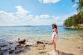 Beautiful slender girl relaxing on the rocky beach of a large la Royalty Free Stock Photo