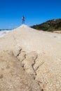 A beautiful slender girl stands on top of an inactive mud volcano