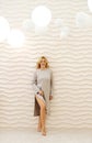 Beautiful slender mature woman posing against a beige wall with wavy lines. Woman smiling and looking at the camera Royalty Free Stock Photo