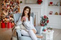 Beautiful slender and brunette girl sits in a cozy armchair Royalty Free Stock Photo