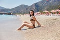 Beautiful slender woman in a swimsuit is relaxing on the beach in Turkey. Tourist holidays in Fethiye