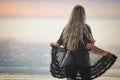 A girl with blond chic hair in a black bikini and a lace shawl walks along the estuary Royalty Free Stock Photo