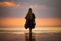 A girl with blond chic hair in a black bikini and a lace shawl walks along the estuary Royalty Free Stock Photo