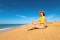 Beautiful slim and attractive caucasian young woman in a yellow swimsuit and top wearing a straw hat enjoys the sea Royalty Free Stock Photo