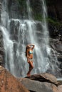 Beautiful slim fitness model posing in front of waterfalls Royalty Free Stock Photo