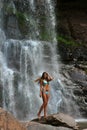 Beautiful slim fitness model posing in front of waterfalls Royalty Free Stock Photo