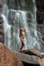 Beautiful slim fitness model posing in front of waterfalls Royalty Free Stock Photo