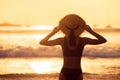 Beautiful slim girl with hat against sunset sea beach Royalty Free Stock Photo