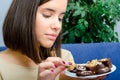 Beautiful slim happy young girl eating dessert cookies at home Royalty Free Stock Photo