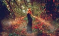 Beautiful slim redhead witch conjures in the woods Royalty Free Stock Photo