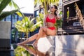 Beautiful slim woman wearing red bikini relax near outdoor water pool on resort Royalty Free Stock Photo