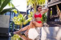Beautiful slim woman wearing red bikini relax near outdoor water pool on resort Royalty Free Stock Photo