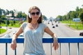 Beautiful slim stylish girl student stands on the car bridge and Royalty Free Stock Photo