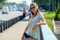 Beautiful slim stylish girl student stands on the car bridge and Royalty Free Stock Photo