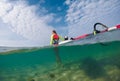 beautiful slim windsurfer girl walking along the sandy bottom Royalty Free Stock Photo