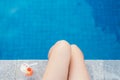 Beautiful slim women legs by the swimming pool and fresh tricolor cocktails. Summer holidays, travel, vacation concept.
