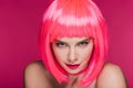 Beautiful sly girl in neon pink wig looking at camera, isolated Royalty Free Stock Photo