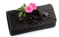 Beautiful small black clutch with fresh pink twig of flower rose