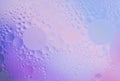 Beautiful small bubbles of oil on surface of the water. Delicate cosmetic violet-blue background for advertising Royalty Free Stock Photo