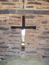 Cross molded into a wall, built with bricks and wood.