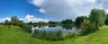 A beautiful small lake in the countryside. Sunny day with clouds in the sky. Royalty Free Stock Photo