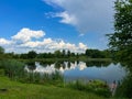 A beautiful small lake in the countryside. Sunny day with clouds in the sky. Royalty Free Stock Photo