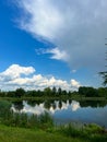 A beautiful small lake in the countryside. Sunny day with clouds in the sky. Royalty Free Stock Photo