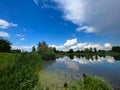 A beautiful small lake in the countryside. Sunny day with clouds in the sky. Royalty Free Stock Photo