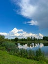 A beautiful small lake in the countryside. Sunny day with clouds in the sky. Royalty Free Stock Photo