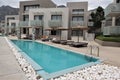 Beautiful small luxury hotel swimming pools with umbrellas and deck chairs in front of each apartments Royalty Free Stock Photo