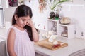 Beautiful small middle eastern girl crying in kitchen, tears of onion. studio shot.