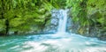Beautiful small waterfall located inside of a green forest with stones in river at Mindo Royalty Free Stock Photo