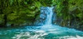 Beautiful small waterfall located inside of a green forest with stones in river at Mindo Royalty Free Stock Photo