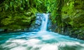 Beautiful small waterfall located inside of a green forest with stones in river at Mindo Royalty Free Stock Photo
