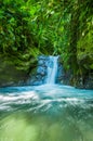 Beautiful small waterfall located inside of a green forest with stones in river at Mindo Royalty Free Stock Photo