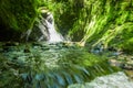 Beautiful small waterfall located inside of a green forest with stones in river at Mindo Royalty Free Stock Photo