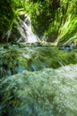 Beautiful small waterfall located inside of a green forest with stones in river at Mindo Royalty Free Stock Photo