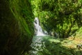 Beautiful small waterfall located inside of a green forest with stones in river at Mindo Royalty Free Stock Photo