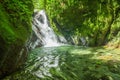 Beautiful small waterfall located inside of a green forest with stones in river at Mindo Royalty Free Stock Photo